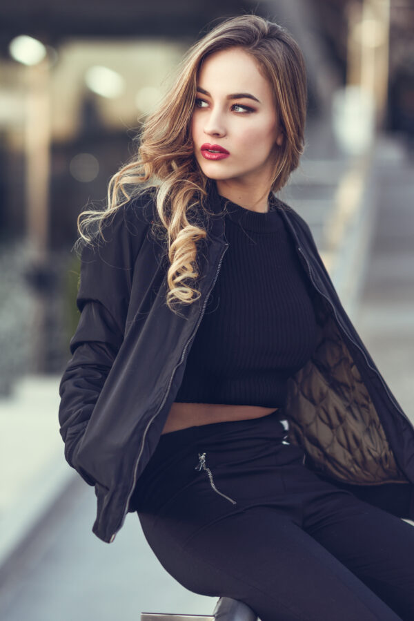 Beautiful young girl wearing black jacket sitting in the street. Przebojowy czarny zestaw